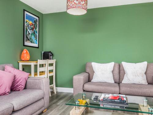 a living room with two couches and a green wall at Modern Comfortable Home Pass The Keys in Chichester