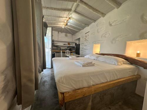 1 dormitorio con 1 cama con mesa y cocina en Richie's Sea View Romantic Residences, en Ándros