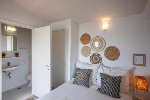 1 dormitorio con 1 cama con 2 almohadas y baño en Alterra Vita Captain's Cabin en Neos Marmaras