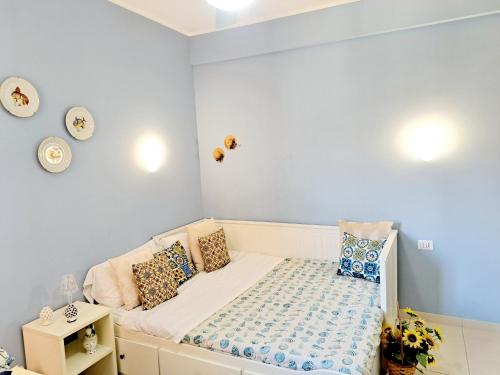 a small bedroom with a bed with blue walls at Appartamento Castel Sant'Angelo in Licata