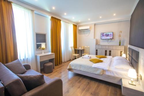 a bedroom with a bed and a living room with a couch at Hotel Terrace Kutaisi in Kutaisi