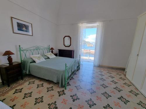 a bedroom with a bed and a large window at Maridea - Corso Umberto in Ponza