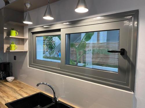 a kitchen with two windows and a sink at villa kate view in Ratzaklíon