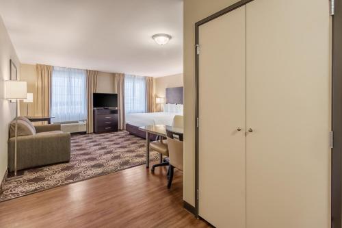a hotel room with a king bed and a table at Landmark Suites - Williston in Williston