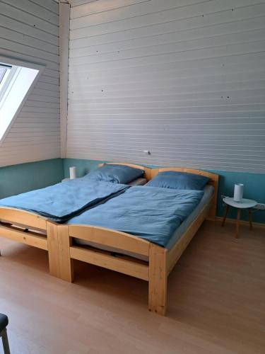 ein Holzbett in einem Zimmer mit Fenster in der Unterkunft Haus Windmühle Obergeschoß in Norden