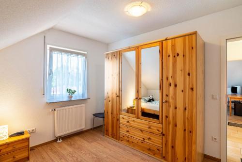 a bedroom with a wooden cabinet and a bed at Schwalbenhof Dreßler und Duss für 6 in Bad Herrenalb