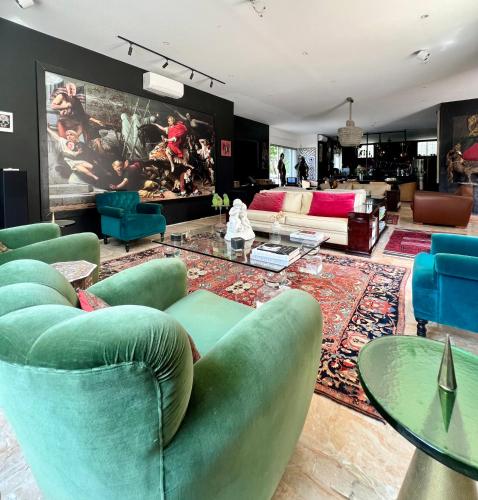 a living room with green chairs and a table at Villa Pauline in Avignon
