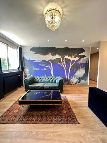 a living room with a couch and a tree mural at Villa Pauline in Avignon