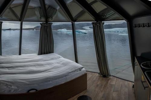 a bed in a tent with a view of the water at Fjallsarlon - Overnight adventure in Hof