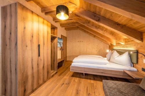 a bedroom with a bed in a room with wooden walls at Poolchalet Dachsteinblick in Pruggern