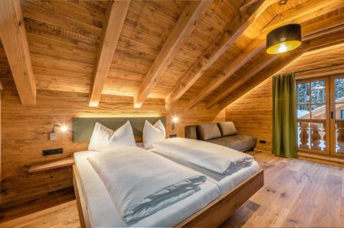 a bedroom with a large bed in a wooden room at Poolchalet Dachsteinblick in Pruggern