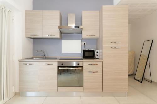 a kitchen with wooden cabinets and a microwave at Hotel Croce Del Sud in Rimini