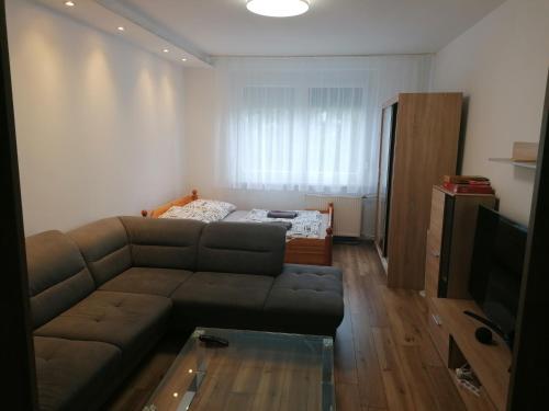 a living room with a couch and a bed at Borsalino Apartman in Veszprém