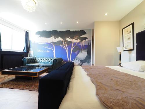 a bedroom with a bed and a couch and a tree mural at Villa Pauline in Avignon