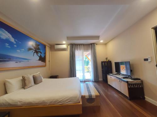 a hotel room with a bed and a television at 芭提雅市中心4间卧室泳池别墅好莱坞Hollywood旁-19 in Pattaya Central