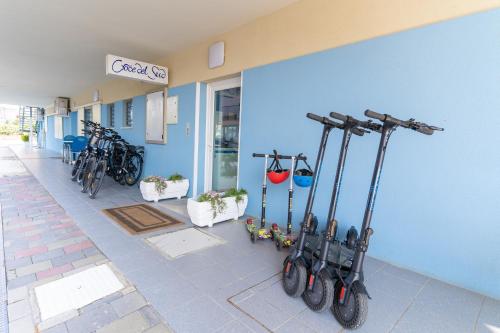a group of bikes parked next to a blue wall at Hotel Croce Del Sud in Rimini