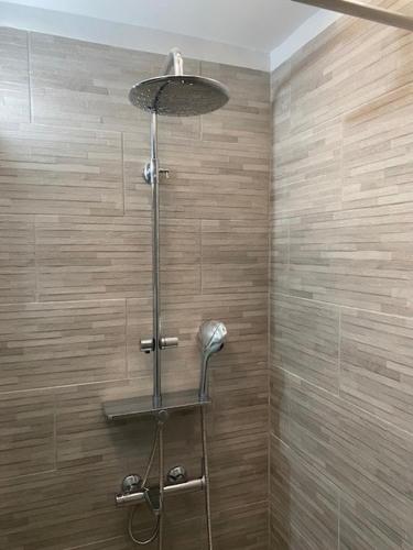 a shower with a shower head in a bathroom at Spata Lykourgos Homes in Spata