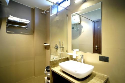 a bathroom with a sink and a mirror at Hotel Rich Comfort Ajmer in Ajmer
