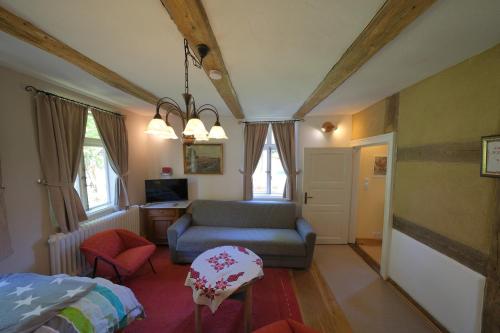 um quarto com uma cama, um sofá e uma cadeira em Thölkes Hus em Bötersen
