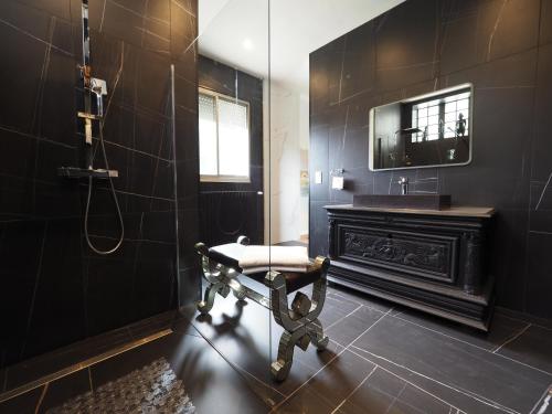 a bathroom with a bench and a sink and a mirror at Villa Pauline in Avignon