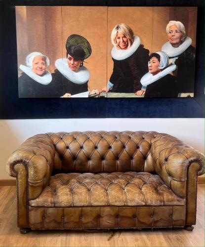 a couch in a room with a painting of a group of people at Villa Pauline in Avignon