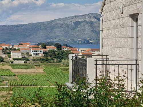 un edificio con vistas a un campo y a una montaña en VILLA Apartments Mate Cebalo en Lumbarda