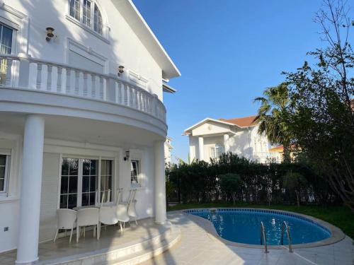 una casa blanca con piscina frente a ella en Luxury Private Villa in the Belek Center, en Belek
