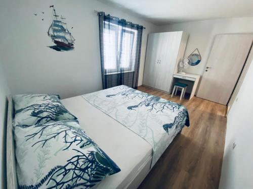 a bedroom with a bed with a blue and white comforter at ADRIATIC APARTMENT center II MAKARSKA in Makarska