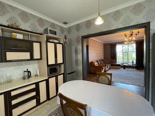 cocina y sala de estar con mesa y comedor en Гостевой дом, en Shchūchīnsk