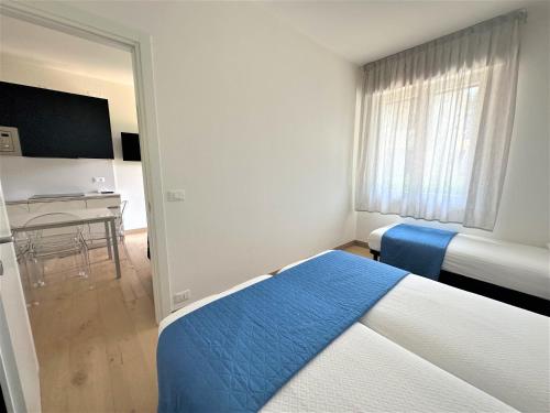 sypialnia z 2 łóżkami, biurkiem i telewizorem w obiekcie Villaggio Azzurro Plus w Bibione