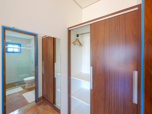 a bathroom with a wooden door and a toilet at Pousada Ouro Preto de Bonito in Bonito