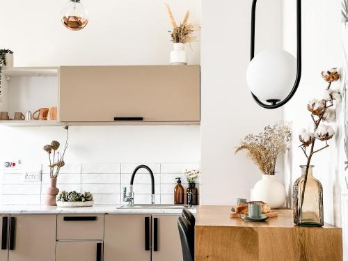 a kitchen with white cabinets and a wooden table at בקתות שחר in Yonatan