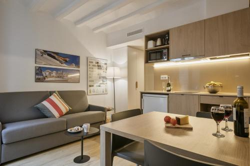 a living room with a couch and a table with wine glasses at Ola Living Vidreria in Barcelona