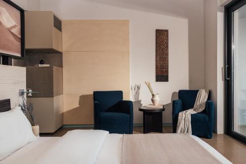 sypialnia z 2 niebieskimi krzesłami i łóżkiem w obiekcie Life Gallery Athens w Atenach