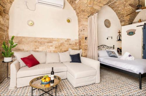 a living room with a white couch and a table at Napoleon with rooftop terrace in ‘Akko