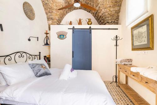 1 dormitorio con 1 cama y puerta azul en Napoleon with rooftop terrace, en Acre
