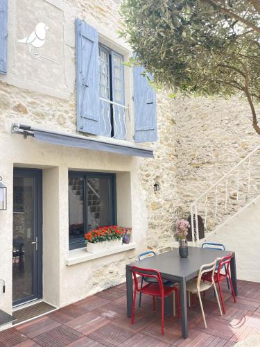 a table and chairs in front of a building at L'oiseau Bleu suite MERLE BLEU in Roubia