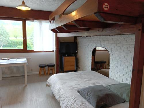 a bedroom with a large bed with a brick fireplace at La Marjolaine in Annecy