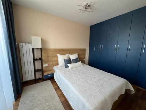 a bedroom with a large bed with blue cabinets at Cozy and bright apartment in Sofia