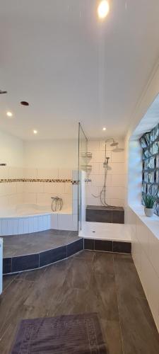 a large bathroom with a shower and a sink at Ferienhaus Romy in Hohenfels-Essingen