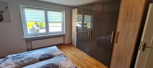 a bedroom with a bed and a shower and a window at Ferienhaus Romy in Hohenfels-Essingen