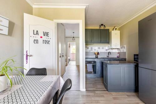 a kitchen with a table and a door to a kitchen with a counter at Cocooning in Mont-de-Marsan