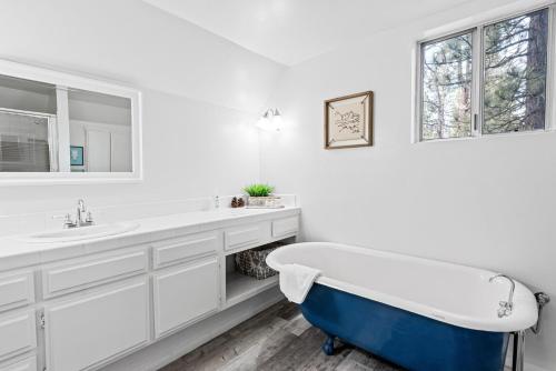 une salle de bain blanche avec une baignoire et un lavabo dans l'établissement Pinecone Escape - Close to Lake and Slopes, à Big Bear City