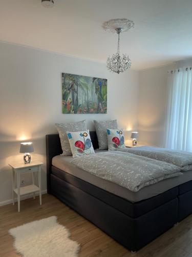 a bedroom with a large bed with a chandelier at Luxury Apartment Amina in Siedlung Schönwalde