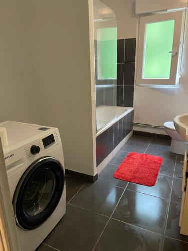 a washing machine in a bathroom with a tub at senechal in Lorette