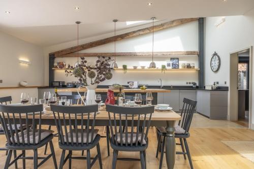 a kitchen and dining room with a table and chairs at Fitters Barn in Warham