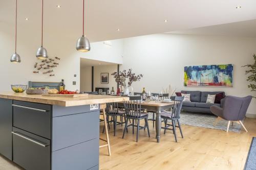 a kitchen and living room with a table and chairs at Fitters Barn in Warham