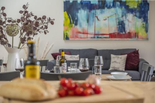 a dining room table with wine glasses and a couch at Fitters Barn in Warham
