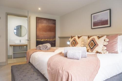 a bedroom with two beds and a mirror at Fitters Barn in Warham