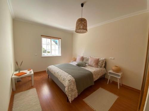 a bedroom with a bed and a table and a window at Casa M Falésia in Albufeira